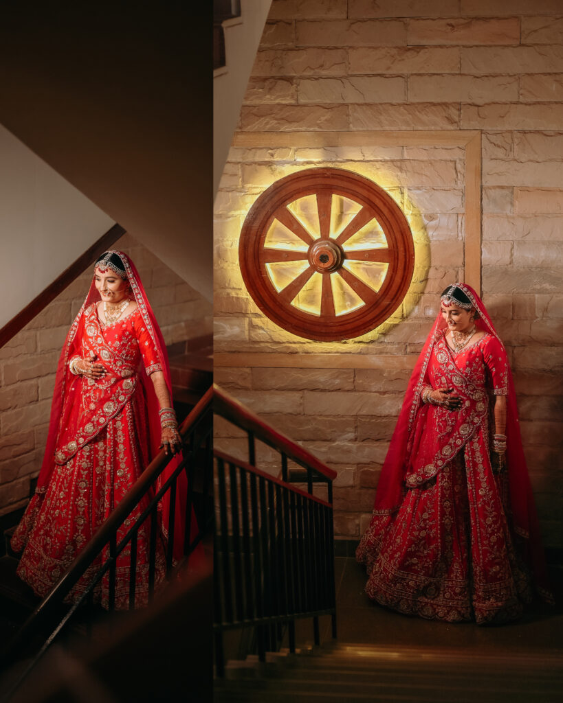 Bride in red lehenga with a veil walking down a staircase beside a lit wooden wheel, wedding photography in Lonavala