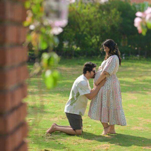 Couple maternity shoot in Solapur with husband holding baby bump